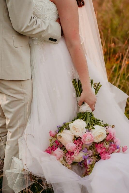 A couple embracing at sunset in a field